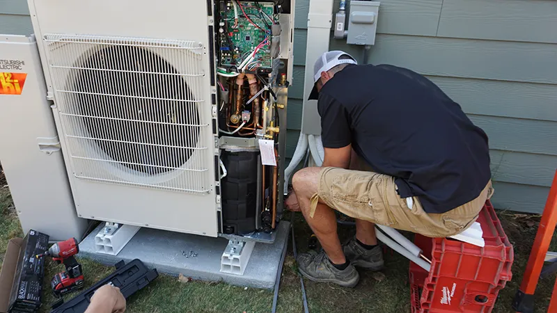 a ductless heat pump technician is installing an outdoor unit