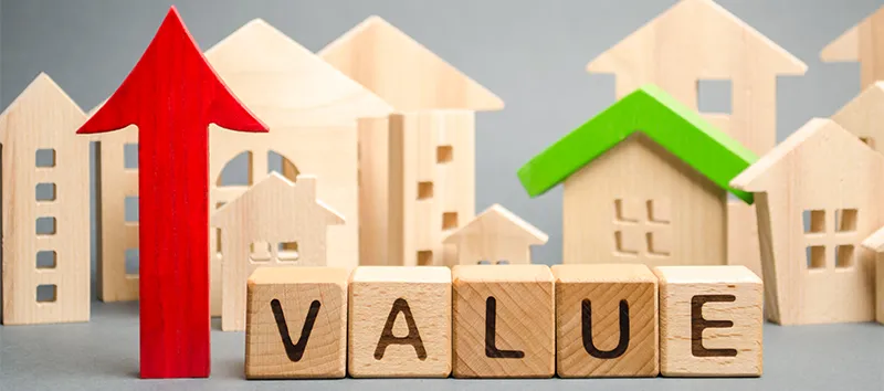 Wooen houses with the word value and a red arrow pointing up