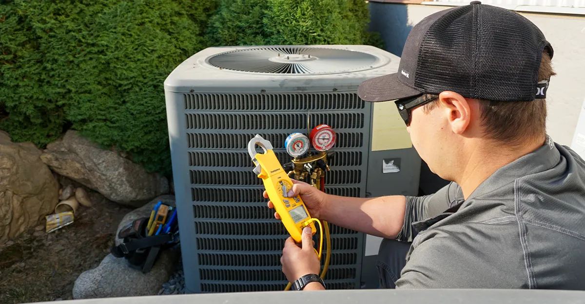 An hvac technician inspects an air conditioner
