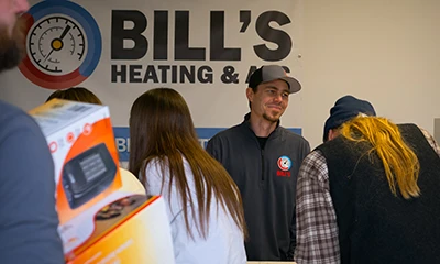 A Bill's Heating & AC's smiles as he talks to a customer from behind the counter in our Lewiston location.