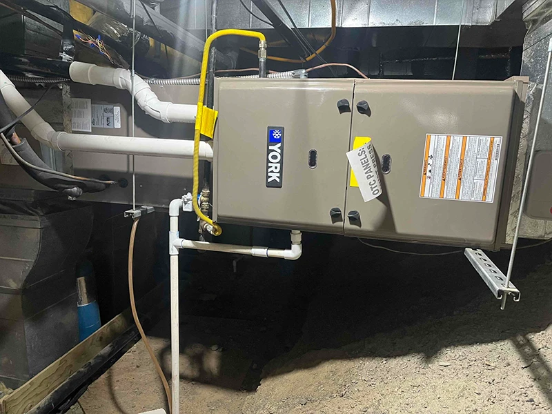 A natural gas furnace installed horizontally in a crawl space with clean and creative duct work connections.