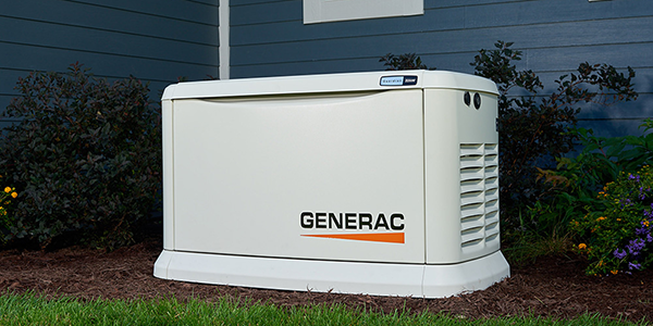 A Generac 24kw standby Generator installed outside a bautiful home in green grass.