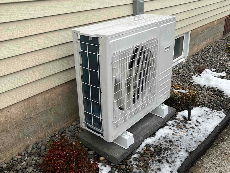 A slim heat pump installed by Bills Heating and AC. The heat pump is white and rectangular.