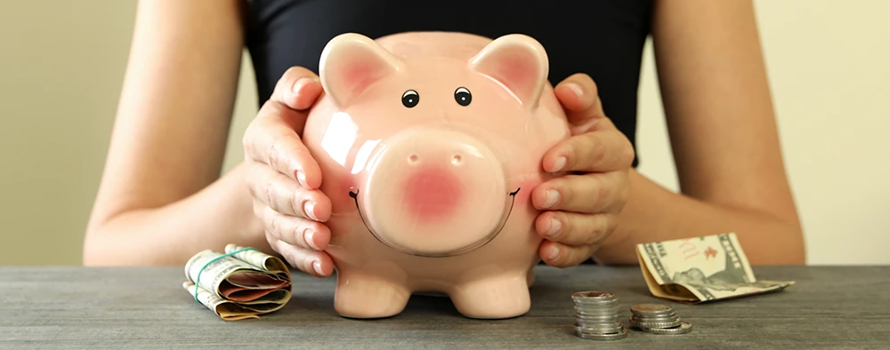 A piggy bank with money around it